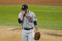 Houston Astros' Ryan Pressly (55) wipes his face as he walks to the dugout in the ninth inning of a baseball game against the Texas Rangers in Arlington, Texas, Friday, Sept. 25, 2020. Pressly gave up a tying solo home run to Rangers' Ronald Guzman in the inning. (AP Photo/Tony Gutierrez)