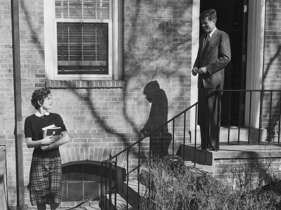 Senator John F. Kennedy, Democrat of Massachusetts, says goodbye to his wife,  the former Jacqueline Bouvier, who is on her way to classes at Georgetown University Foreign Service School.