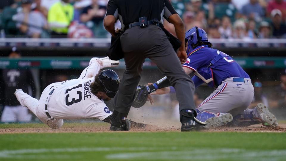 Detroit Tigers' Eric Haase (13) is tagged out at home plate by Texas Rangers catcher Jonah Heim (28) in the third inning at Comerica Park in Detroit on Thursday, June 16, 2022.