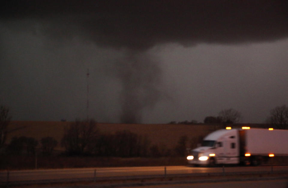 FILE- A tornado approaches Interstate 80 near Atlantic, Iowa, as a semi truck rolls eastward on Wednesday, Dec. 15, 2021. The National Weather Service has declared the series of thunderstorms and tornadoes that swept across the Great Plains and upper Midwest on Dec. 15 as a serial derecho, a rare event featuring a very lengthy and wide line of storms. The service said it was the first-ever serial derecho in December in the U.S. (Bryon Houlgrave/The Des Moines Register via AP)