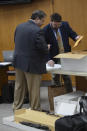 Assistant District Attorneys Rodney Tidwell, left, and Robert Byrd organize ballistic evidence and weapons Friday, Feb. 21, 2020, that were recovered at East Lincoln Road where two people were shot and killed May 28, 2017, in an overnight rampage. The state is on Day 7 of testimony in Willie Cory Godbolt's capital murder trial in the Pike County Courthouse in Magnolia, Miss. Godbolt, 37, is on trial, for the May 2017 shooting deaths of eight people in Brookhaven, Miss. (Donna Campbell/The Daily Leader via AP, Pool)