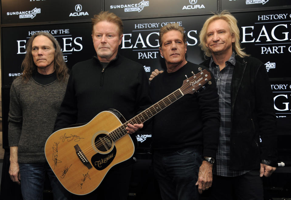 FILE - Members of The Eagles, from left, Timothy B. Schmit, Don Henley, Glenn Frey and Joe Walsh pose with an autographed guitar after a news conference at the Sundance Film Festival, in Park City, Utah, Jan. 19, 2013. Henley, the co-founder of classic rock band the Eagles, is scheduled to testify Monday, Feb. 26, 2024, at the criminal trial of three collectibles professionals. They're charged with colluding to veil the questioned ownership of sheets of draft lyrics to “Hotel California” and other Eagles hits in order to sell them and deflect Henley’s demands for their return. (Photo by Chris Pizzello/Invision/AP, File)