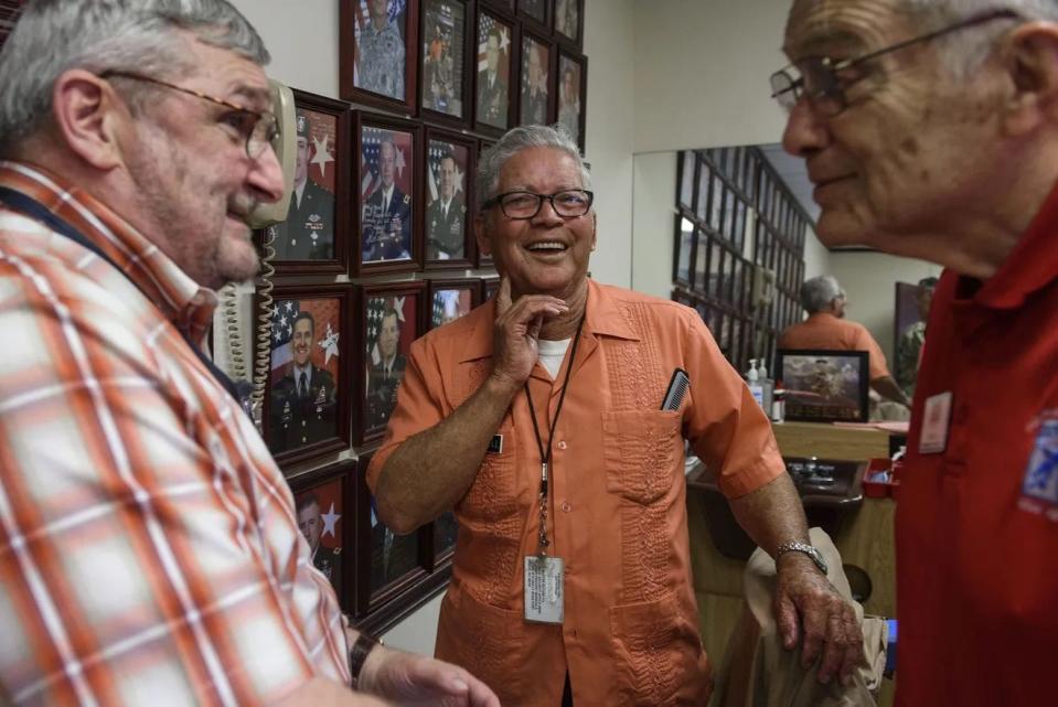 Retired Army Sgt. Maj. Gary Brode, left, barber Travis Bell and Jack Cox, share stories of their 40 years of friendship with Bell at his one-chair barber studio at Fort Bragg's 18th Airborne Corps headquarters in July 2017.