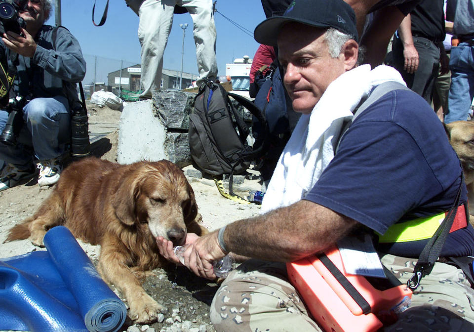 Scott Shields, right, gives his rescue dog "Bear" water from a bottle after coming out the World Trade Center disaster site in this Sept. 13, 2001 file photo. The North Shore Animal League America has offered to pay medical bills and provide lifetime care for Bear, the famous search dog that suffers from ailments his owner says were incurred during recovery work at the World Trade Center site. (AP Photo/Beth A. Keiser, FILE )