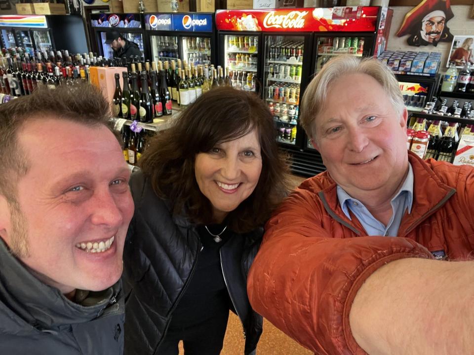 Traverse City liquor store manager John Butler, left, gave some spare cartons to Anne Stanton, center – and wound up meeting one of his favorite authors, Doug Stanton.