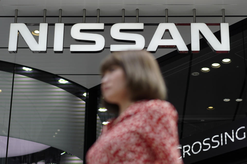 File - In this July 25, 2019, file photo, a pedestrian walks past a Nissan car gallery in Tokyo. Japanese automaker Nissan Motor Co. has named the head of its China business, Makoto Uchida, to be its new CEO. (AP Photo/Eugene Hoshiko, File)