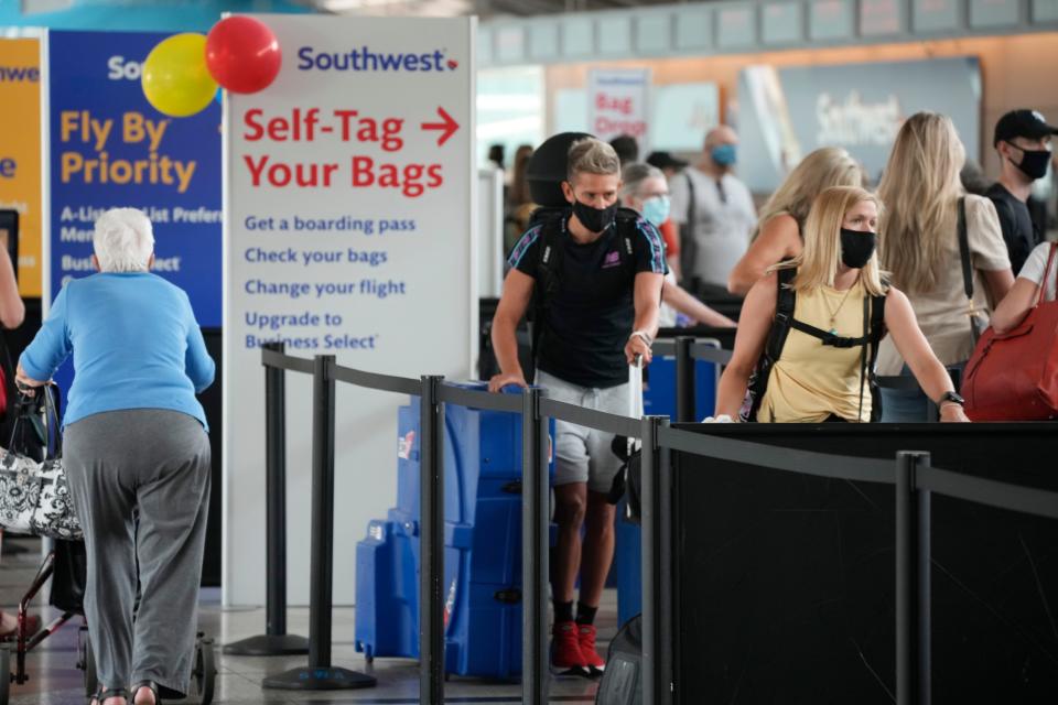 Travelers wearing masks line up at an airport in Colorado.