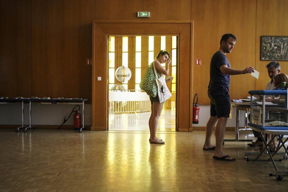 A voter submits his ballot in the first round of the French parliamentary election in Lyon, central France, Sunday June 12, 2022. Voters are choosing lawmakers as President Emmanuel Macron seeks to secure his majority while under growing threat from a leftist coalition. (AP Photo/Laurent Cipriani)