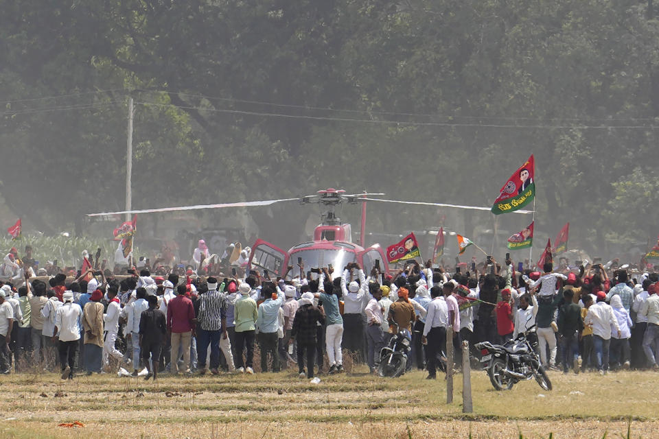 FILE-Supporters of Samajwadi Party rush toward a helicopter bringing party leader Akhilesh Yadav to the venue of an election rally by Indian National Developmental Inclusive Alliance (INDIA) in Prayagraj, Uttar Pradesh, India, Sunday, May 19, 2024. (AP Photo/Rajesh Kumar Singh, file)