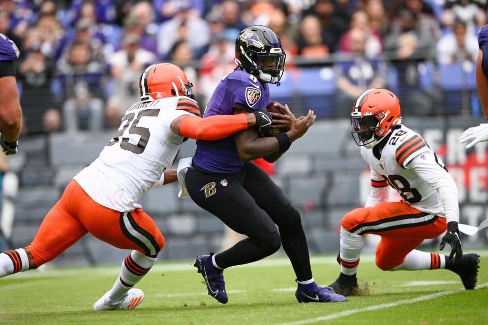 Baltimore Ravens quarterback Lamar Jackson (8) is wrapped up by Cleveland Browns defensive end Myles Garrett (95) as linebacker Jeremiah Owusu-Koramoah (28) closes in in the first half of an NFL football game, Sunday, Oct. 23, 2022, in Baltimore. (AP Photo/Nick Wass)