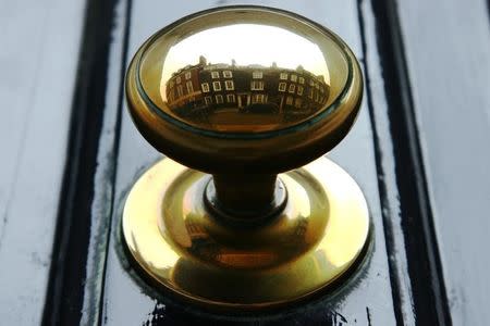 Houses are reflected in the door handle of a property in central London in this August 18, 2008 file photo. REUTERS/Luke MacGregor