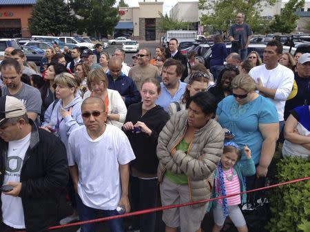 Parents wait behind police tape for students from Reynolds High School to arrive by bus in Troutdale, Oregon June 10, 2014. REUTERS/Steve Dipaola