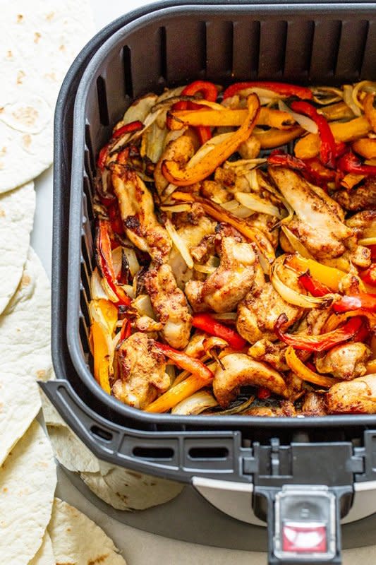 <p>Who knew you could use the air fryer to make chicken fajitas for dinner? All you have to do is combine sliced chicken, peppers, and onions with fajita seasoning in the tray.</p><p><strong>Get the recipe<em>:</em> <a href="https://cookthestory.com/air-fryer-chicken-fajitas/" rel="nofollow noopener" target="_blank" data-ylk="slk:Air Fryer Chicken Fajitas;elm:context_link;itc:0;sec:content-canvas" class="link rapid-noclick-resp">Air Fryer Chicken Fajitas</a></strong></p>