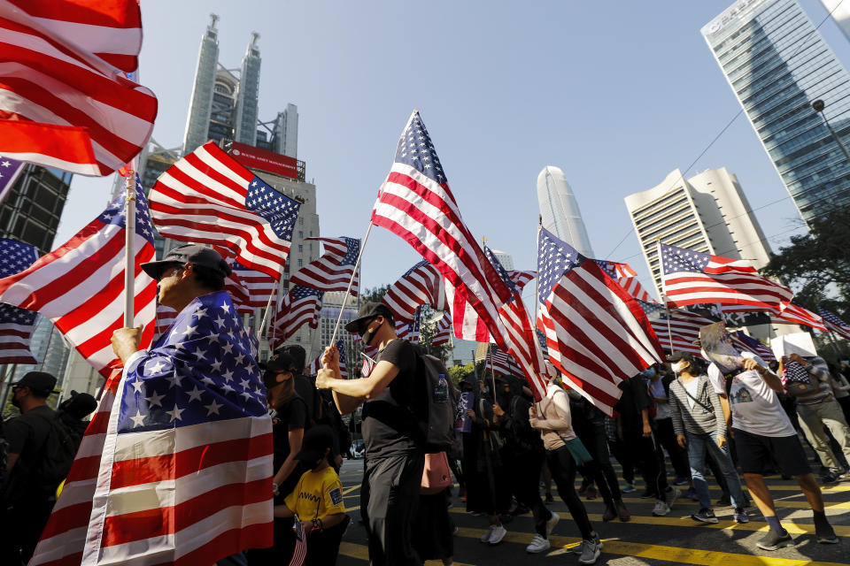 Protesters march to U.S. Consulate during a rally in Hong Kong, Sunday, Dec. 1, 2019. Hong Kong protesters carrying American flags and banners appealing to President Donald Trump are rallying in the semi-autonomous Chinese territory. (AP Photo/Vincent Thian)