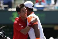 Mar 26, 2017; Miami, FL, USA; Kei Nishikori of Japan (L) hugs Fernando Verdasco of Spain (R) after their match on day six of the 2017 Miami Open at Crandon Park Tennis Center. Mandatory Credit: Geoff Burke-USA TODAY Sports