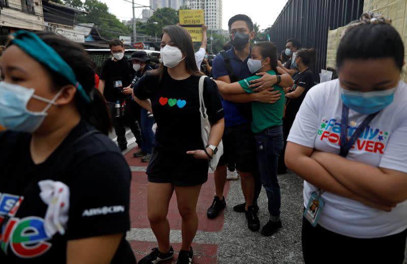 ABS-CBN employees react after the Philippine congress voted against the renewal of the broadcast network's 25-year franchise, outside ABS-CBN headquarters, in Quezon City