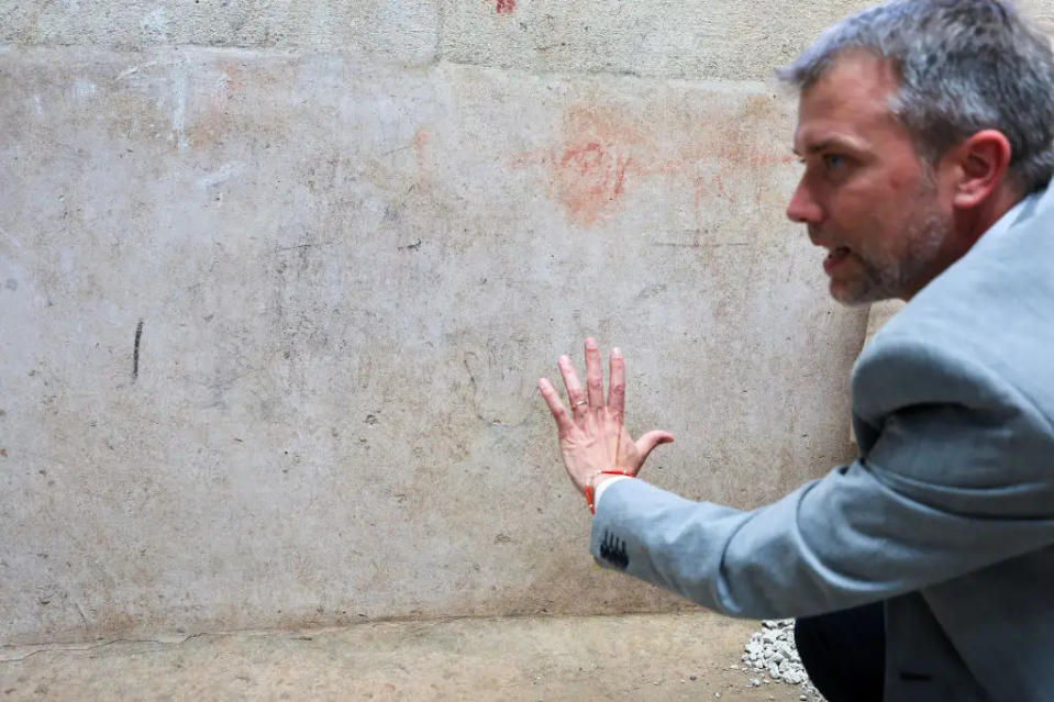 Der Leiter der Ausgrabungen in Pompeji, Gabriel Zuchtriegel, zeigt den Umriss einer Hand aus Holzkohle, die wahrscheinlich von einem Kind angefertigt wurde - Copyright: Marco Cantile/LightRocket via Getty Images