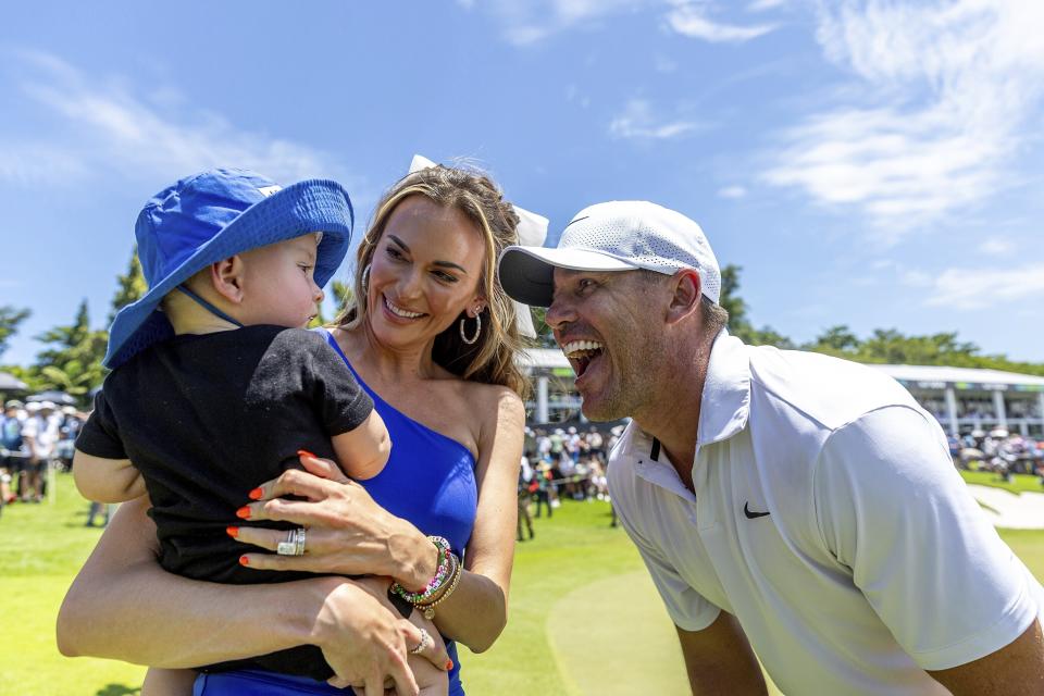 Individual champion Captain Brooks Koepka, right, of Smash GC, celebrates after his win with his wife Jena Sims, center, and son Crew, left, on the 18th green after the final round of LIV Golf Singapore at Sentosa Golf Club, Sunday, May 5, 2024, in Sentosa, Singapore. (Jon Ferrey/LIV Golf via AP)