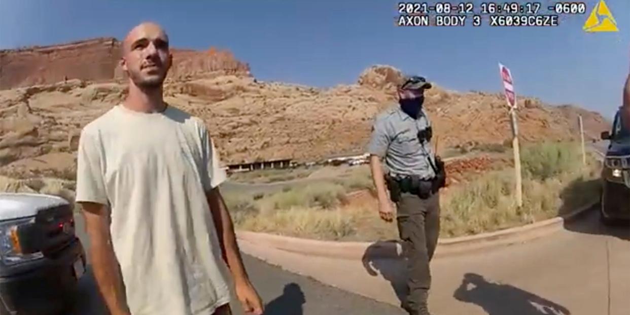 Brian Laundrie in the desert with a cop behind him