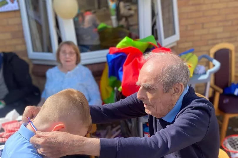 Thomas Bow, 83, handing out a sports day medal