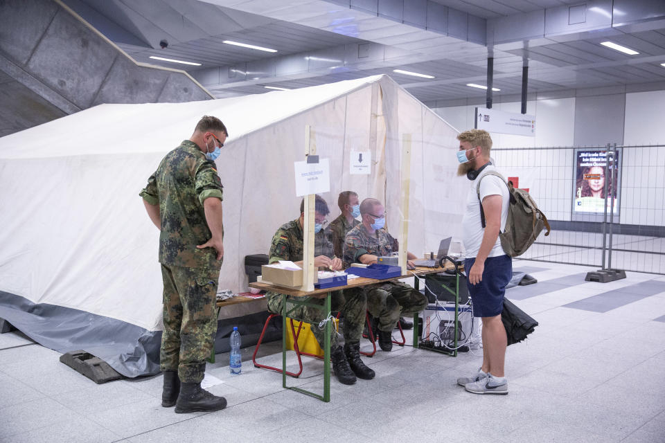 BERLIN, GERMANY - AUGUST 18: Members of the German army collect information from a person at a Covid-19 testing station set up at Berlin main railway station (Hauptbahnhof) during the coronavirus pandemic on August 18, 2020 in Berlin, Germany. German authorities are expanding their testing of travelers arriving from abroad in an effort to stem the spread of the virus. Germany has seen an uptake in infections over the last month, which health authorities attribute to people returning from their holidays in countries that have become coronavirus higher-risk areas. (Photo by Maja Hitij/Getty Images)