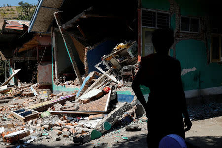 A villager stands in front of a damaged classroom after an earthquake hit Lombok island in Pamenang, Indonesia August 6, 2018. REUTERS/Beawiharta