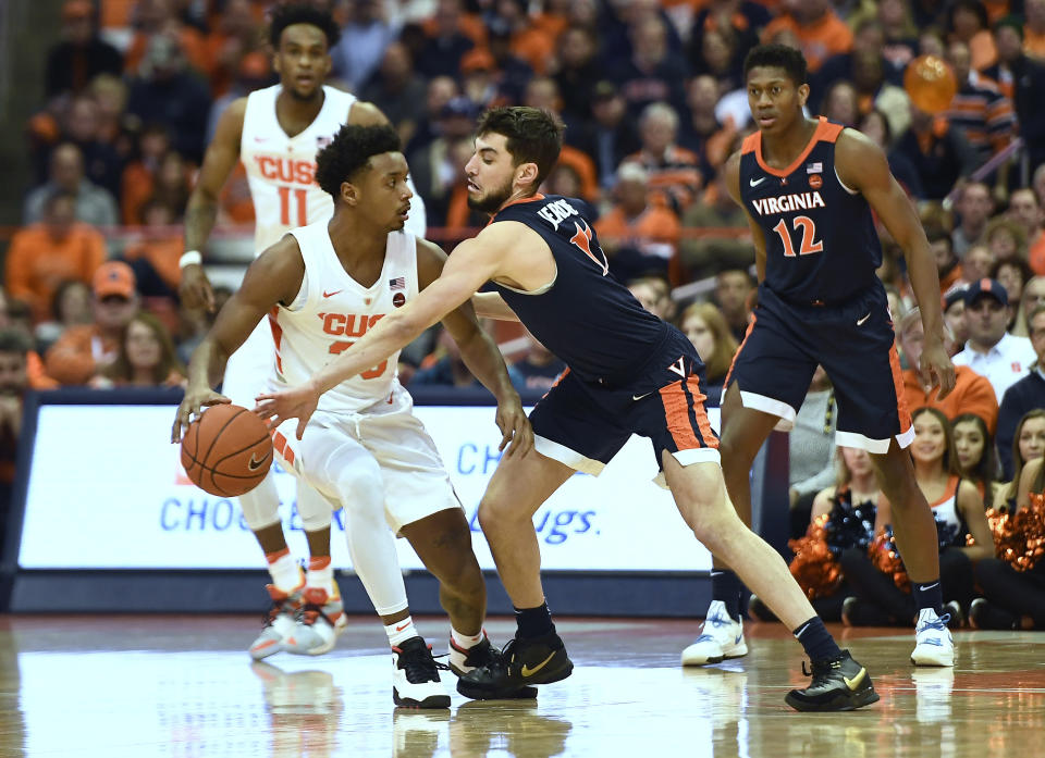 Syracuse forward Elijah Hughes, left, has the ball tipped away by Virginia guard Ty Jerome during the first half of an NCAA college basketball game in Syracuse, N.Y., Monday, March 4, 2019. (AP Photo/Adrian Kraus)