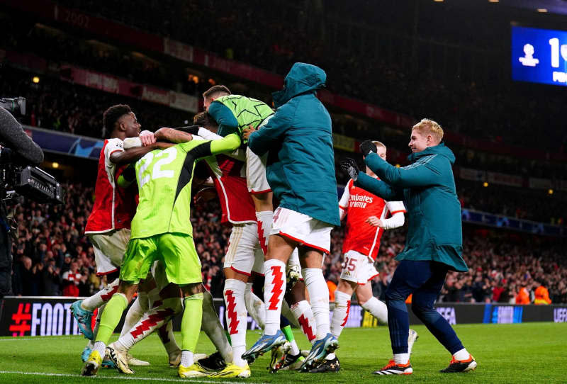 Arsenal players celebrate after winning the penalty shoot-out of the UEFA Champions League Round of 16, second leg soccer match between Arsenal and FC Porto at the Emirates Stadium. Zac Goodwin/PA Wire/dpa