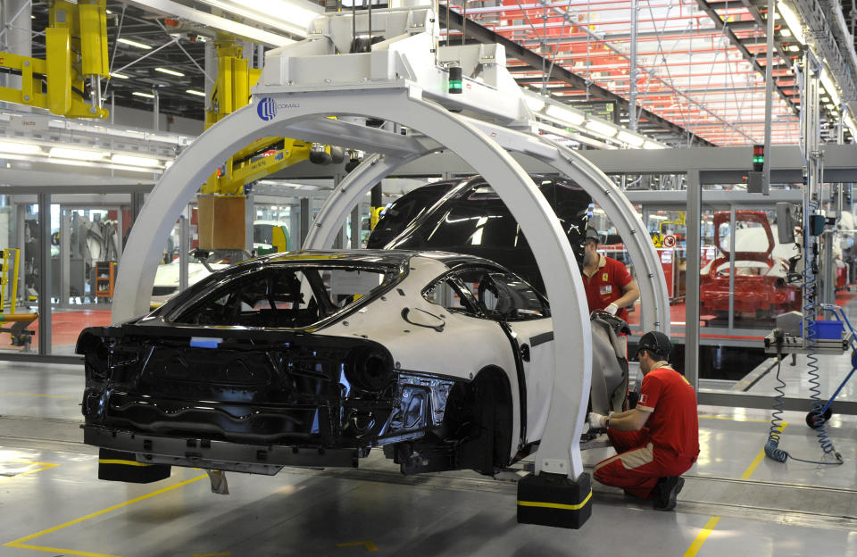 FILE - In this Wednesday, May 8, 2013 file photo, a technician works at the Ferrari department factory in Maranello, Italy. The eurozone's third-largest economy and a major exporter, Italy on Wednesday becomes the first western industrialized nation to idle swaths of industrial production to stop the spread of coronavirus by keeping yet more of the population at home. The new coronavirus causes mild or moderate symptoms for most people, but for some, especially older adults and people with existing health problems, it can cause more severe illness or death. (AP Photo/Marco Vasini, File)