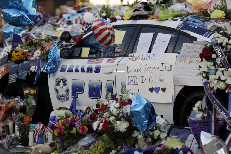 Notes, flowers and other items decorate a squad car at a make-shift memorial in front of the Dallas police department, Saturday, July 9, 2016, in Dallas. (Photo: Eric Gay/AP)