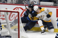 Winnipeg Jets' Logan Stanley (64) collides with Nashville Predators' Eeli Tolvanen (28) during the first period of NHL hockey game action in Winnipeg, Manitoba, Saturday, Oct. 23, 2021. (Fred Greenslade/The Canadian Press via AP)