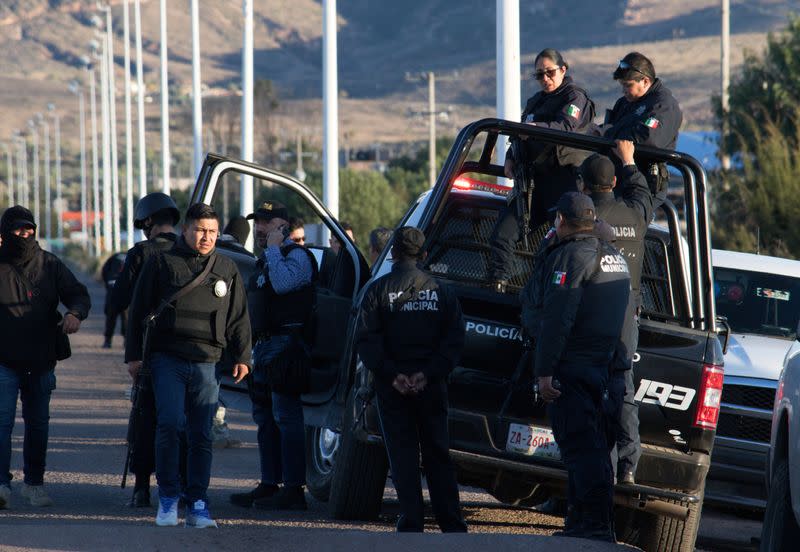 Police officers stand atop a vehicle as they keep watch outside the prison after sixteen inmates were killed and five were wounded in a prison fight at the Regional Center for Social Reintegration in the town of Cieneguillas