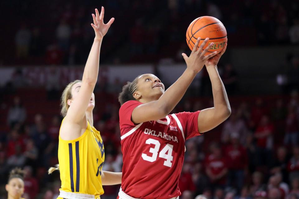 OU forward Liz Scott (34) puts up a shot beside West Virginia forward Kylee Blacksten (14) during the Sooners' 93-68 win Saturday at Lloyd Noble Center in Norman.