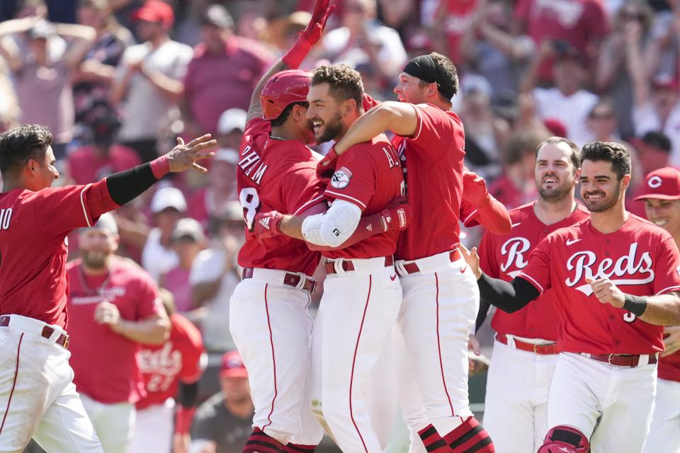 Cincinnati Reds right fielder Albert Almora Jr., center, celebrates with teammates after hitting the game-winning single during the ninth inning of a baseball game, defeating the Atlanta Braves 4-3, Sunday, July 3, 2022, in Cincinnati.