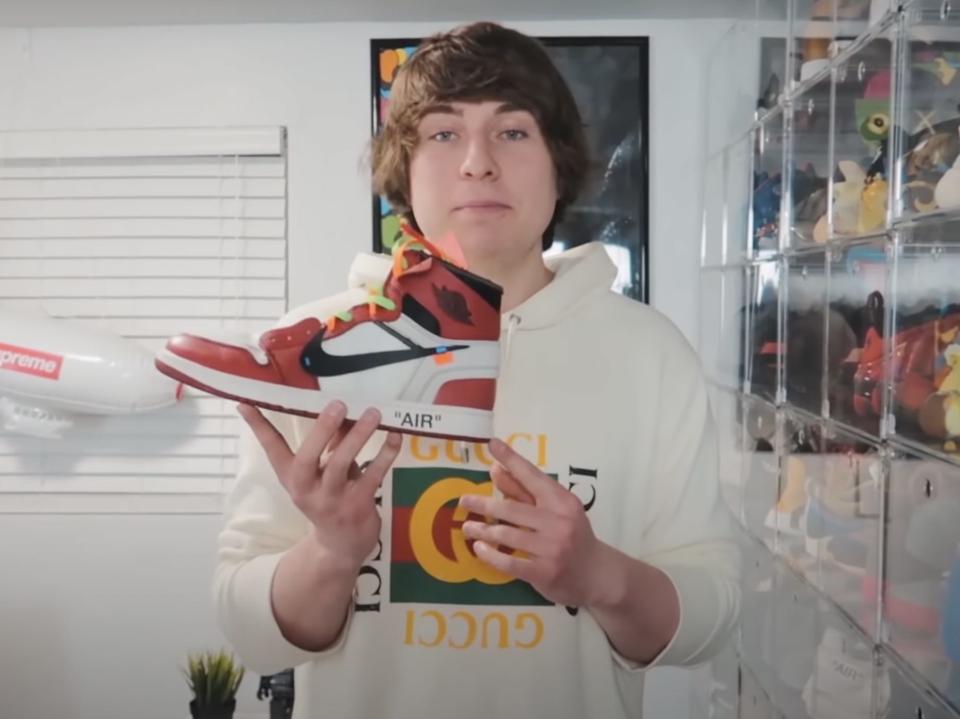 Matthew Beem holding a red sneaker.