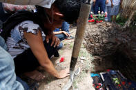 A woman cries near the lowered coffin of police officer Juan Jimenez, who was a victim of the earthquake that struck the southern coast of Mexico late on Thursday, during his burial in Juchitan, Mexico, September 10, 2017. REUTERS/Carlos Jasso