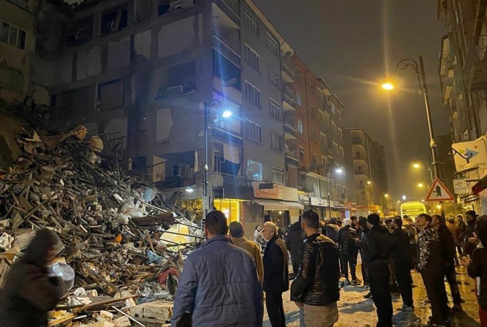 People gather around a collapsed building in Pazarcik, in Kahramanmaras province (Depo Photos)