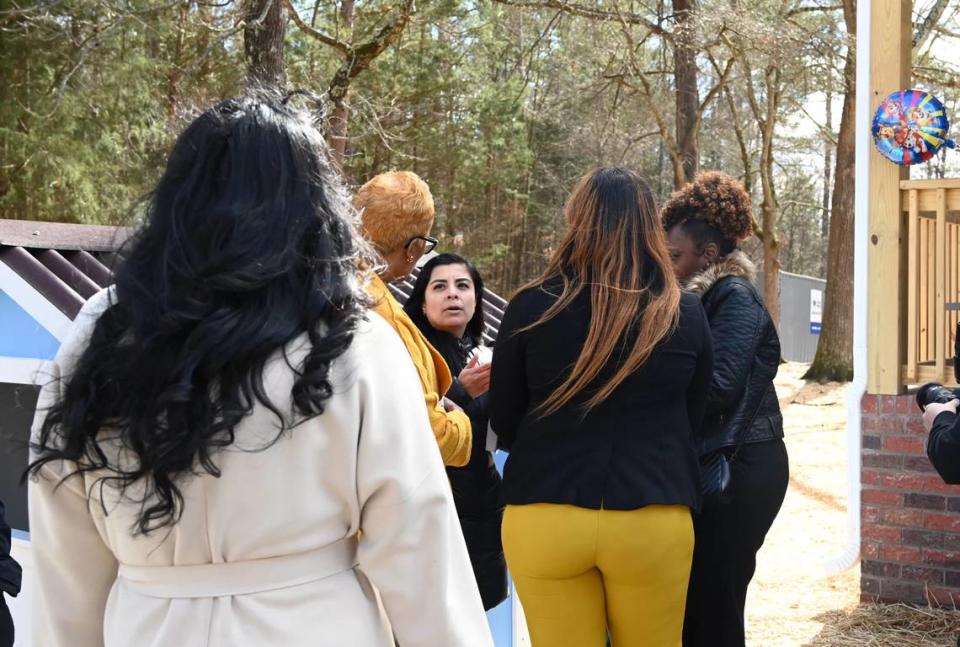 Visitors wait to congratulate Yesenia Rios, center, on receiving the keys to her first home.