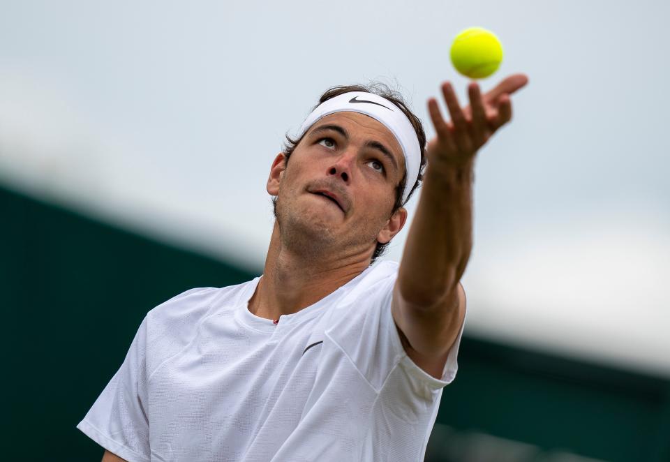 Taylor Fritz tosses the ball to serve during his match against Alastair Gray.