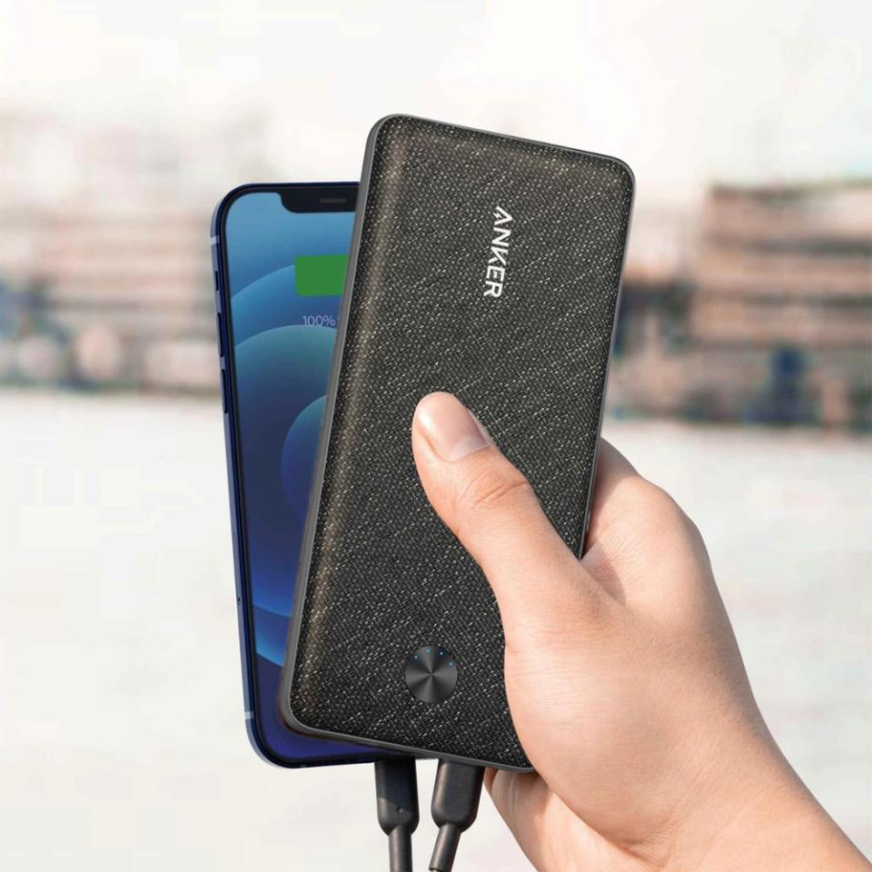 model holding portable charger over smartphone