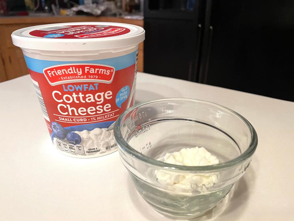 tub of friendly farm cottage cheese next to a glass bowl of friendly farms cottage cheese