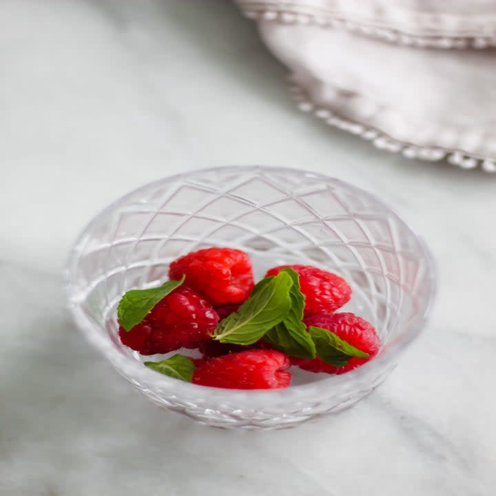 Raspberries and basil in a glass.