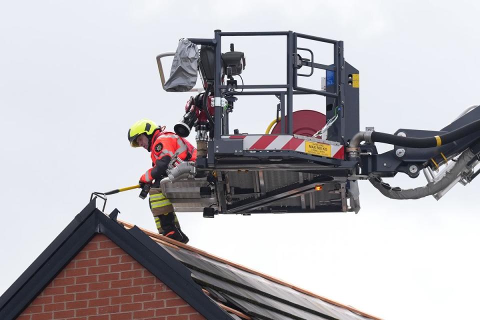Emergency service workers inspect the roof a property in Knutton, North Staffordshire (PA)