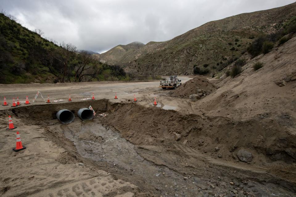 Twin drainage pipes installed under a damaged section of Lake Hughes Road where September