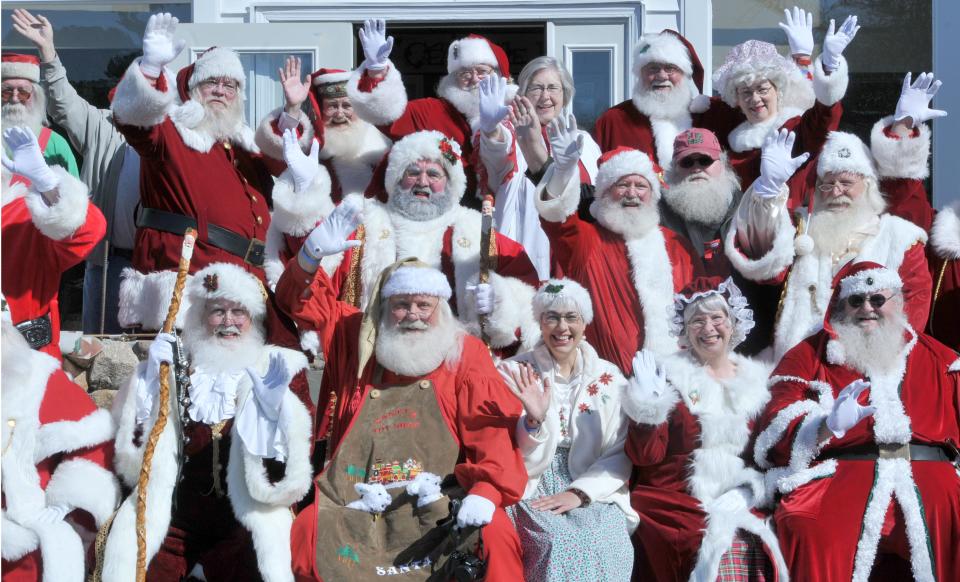 Santas greet passing traffic after a group photo outside the Irish Village as part of the Northeast Santa Convention weekend of activities held there in 2016.