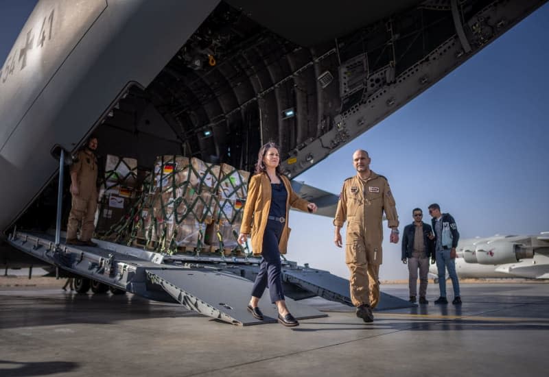 German Foreign Minister Annalena Baerbock (L) comes out of a Bundeswehr A400M airplane with aid supplies for Gaza. Michael Kappeler/dpa
