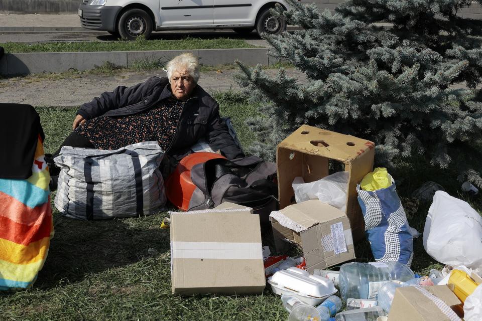 An ethnic Armenian woman from Nagorno-Karabakh rests next to her belongings near a tent camp after arriving to Armenia's Goris in Syunik region, Armenia, on Saturday, Sept. 30, 2023. Armenian officials say that by Friday evening over 97,700 people had left Nagorno-Karabakh. The region's population was around 120,000 before the exodus began. (AP Photo/Vasily Krestyaninov)