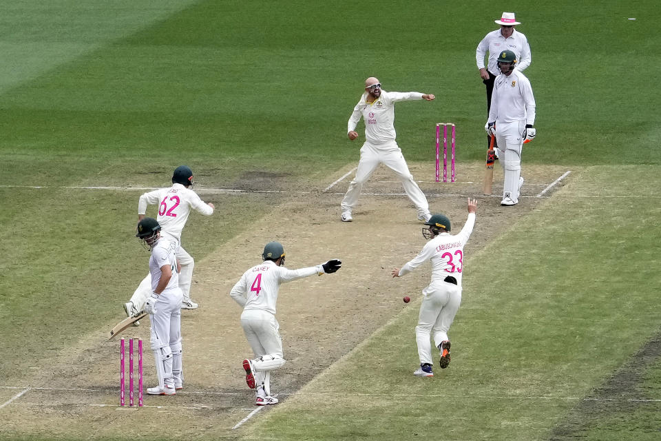 Australia's Nathan Lyon, center, celebrates bowling out South Africa's Sarel Erwee, left, during the fourth day of their cricket test match at the Sydney Cricket Ground in Sydney, Saturday, Jan. 7, 2023. (AP Photo/Rick Rycroft)