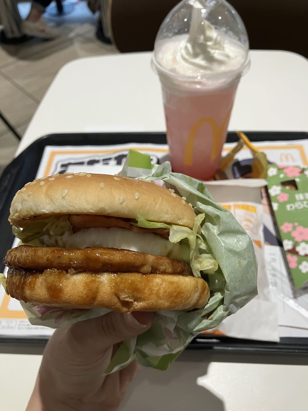 a hand holding a burger