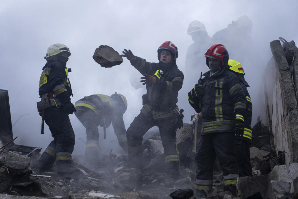 Rescatistas retiran escombros de un edificio de apartamentos destruido por un ataque de cohete ruso en un barrio residencial en la ciudad de Dnipro, en el sureste de Ucrania, el domingo 15 de enero de 2023. (AP Foto/Evgeniy Maloletka)